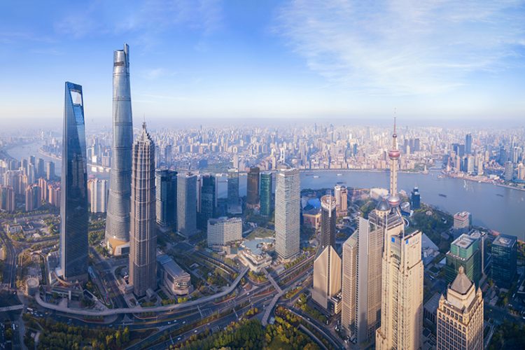 Aerial view of The Pearl at Shanghai Downtown skyline by Huangpu River, China. Financial district and business centers in smart city in Asia. Skyscraper and high-rise buildings near The Bund at noon.